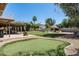 Expansive backyard featuring a putting green, covered patio, and lush landscaping at 10759 N 101St St, Scottsdale, AZ 85260