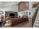 Bright living room with hardwood floors, a large brown leather couch, and staircase at 10759 N 101St St, Scottsdale, AZ 85260