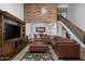 Bright living room showcasing a stylish brown leather couch, fireplace, and adjacent dining area at 10759 N 101St St, Scottsdale, AZ 85260