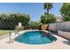 Sparkling in-ground pool surrounded by mature landscaping and a basketball hoop at 10759 N 101St St, Scottsdale, AZ 85260