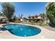 Large in-ground pool surrounded by a lush backyard and a two-story home at 10759 N 101St St, Scottsdale, AZ 85260