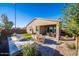 The backyard offers an outdoor kitchen, dining area, artificial turf and a covered patio at 12239 W Caraveo Pl, Peoria, AZ 85383