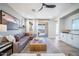 A modern living room with a large sectional sofa, wood-look flooring and outdoor views at 12239 W Caraveo Pl, Peoria, AZ 85383