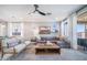 Bright living room with modern furnishings, a ceiling fan, and sliding glass doors to the outdoors at 12239 W Caraveo Pl, Peoria, AZ 85383