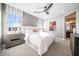 A bedroom featuring a large window and ceiling fan with an attached bathroom at 12239 W Caraveo Pl, Peoria, AZ 85383