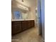 A bathroom with a large vanity, tile flooring, decorative lighting, and a mirror at 12547 W Pasadena Ave, Litchfield Park, AZ 85340