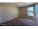 Bedroom featuring a window with damaged blinds and neutral carpeting at 12547 W Pasadena Ave, Litchfield Park, AZ 85340