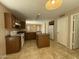 Kitchen features wood cabinets, white appliances, an island, and tile flooring at 12547 W Pasadena Ave, Litchfield Park, AZ 85340