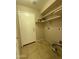 The laundry room has tile flooring and white shelving above the hook ups at 12547 W Pasadena Ave, Litchfield Park, AZ 85340