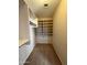 Walk-in closet with custom white shelves and bars for organized storage at 12547 W Pasadena Ave, Litchfield Park, AZ 85340