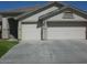 Home exterior featuring an attached two car garage with driveway and manicured lawn at 1412 E Oakland St, Gilbert, AZ 85295