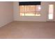 A bright living room showcasing neutral carpet, large windows, and a glass paneled door at 1412 E Oakland St, Gilbert, AZ 85295