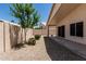 View of the backyard featuring gravel, lush greenery, and a covered patio at 14672 W Whitton Ave, Goodyear, AZ 85395