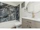 Beautiful bathroom features a marble tiled shower, golden hardware, and a round mirror at 14672 W Whitton Ave, Goodyear, AZ 85395