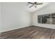 A well-lit bedroom with wood floors, ceiling fan, and a view of the backyard at 14672 W Whitton Ave, Goodyear, AZ 85395