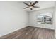 Bright bedroom features wood floors, white walls, ceiling fan and a sunny arched window at 14672 W Whitton Ave, Goodyear, AZ 85395