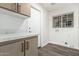 Bright laundry room features cabinets, a marble countertop, and a window at 14672 W Whitton Ave, Goodyear, AZ 85395