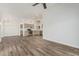 Bright living room leading into a kitchen with wood floors and vaulted ceiling at 14672 W Whitton Ave, Goodyear, AZ 85395