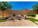 Cozy backyard with artificial turf, seating area with fire pit, and well-manicured landscaping at 16860 W Soft Wind Dr, Surprise, AZ 85387