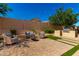 Backyard features artificial turf, outdoor kitchen, gravel, fire pit, and manicured landscaping at 16860 W Soft Wind Dr, Surprise, AZ 85387