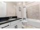 Bright bathroom features a black granite countertop, tiled shower-tub, and modern fixtures at 16860 W Soft Wind Dr, Surprise, AZ 85387