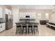 Kitchen showcases an island with seating, complemented by stainless appliances and sleek white cabinetry at 16860 W Soft Wind Dr, Surprise, AZ 85387