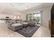 Bright and spacious living room open to the kitchen, featuring a large sectional and tile flooring at 16860 W Soft Wind Dr, Surprise, AZ 85387