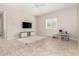 Spacious living room with tile flooring, ceiling fan, and bright natural light from large window at 16860 W Soft Wind Dr, Surprise, AZ 85387