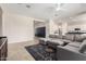 Open-concept living area flowing into the kitchen with a comfortable sectional and tile flooring at 16860 W Soft Wind Dr, Surprise, AZ 85387