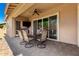 Covered patio featuring ceiling fan, tile floor, and outdoor dining set with a glass table at 16860 W Soft Wind Dr, Surprise, AZ 85387