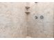 Close up of shower with a stone-look and built-in shelving for convenience at 16860 W Soft Wind Dr, Surprise, AZ 85387