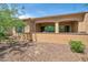 Backyard featuring a covered patio, desert landscaping, and a retaining wall at 16935 W Sheridan St, Goodyear, AZ 85395