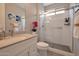 This bathroom has a glass shower, floating shelves, and a white vanity with gray countertops at 16935 W Sheridan St, Goodyear, AZ 85395