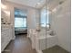 Bathroom showcasing a glass shower, a separate tub, and a view into the bedroom with large sunny windows at 16935 W Sheridan St, Goodyear, AZ 85395