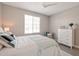 A light bedroom featuring a large window, ceiling fan, and a light and airy color palette at 16935 W Sheridan St, Goodyear, AZ 85395