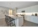 Modern kitchen with white cabinets, stainless steel appliances, a large island, and sleek pendant lighting at 16935 W Sheridan St, Goodyear, AZ 85395