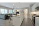 Open-concept kitchen featuring a center island, stainless steel appliances, and views into the living area at 16935 W Sheridan St, Goodyear, AZ 85395