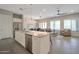 Open concept kitchen and living area with stainless steel appliances, a breakfast bar, and plenty of natural light at 16935 W Sheridan St, Goodyear, AZ 85395