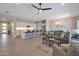 Spacious living room and kitchen area with modern lighting, a ceiling fan, and an eat-in kitchen island at 16935 W Sheridan St, Goodyear, AZ 85395