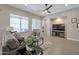 Bright living room with large windows, plush seating, and a modern ceiling fan for a comfortable atmosphere at 16935 W Sheridan St, Goodyear, AZ 85395