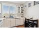 Bright kitchen with white cabinets, a breakfast bar, and a view through plantation shutters at 1701 E Colter St # 443, Phoenix, AZ 85016