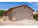 Attached two-car garage with beige siding, complemented by xeriscaped yard at 22508 W Antelope Trl, Buckeye, AZ 85326