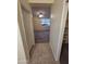 Hallway leading to a bedroom with tan carpet, a ceiling fan, and an organized closet on the right at 22508 W Antelope Trl, Buckeye, AZ 85326