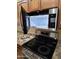 This kitchen features stainless steel appliances, including a microwave and glass cooktop stove, blending modern convenience at 22508 W Antelope Trl, Buckeye, AZ 85326