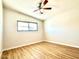 This bedroom features wood plank flooring, a ceiling fan, and a window at 2258 E Alpine Ave, Mesa, AZ 85204
