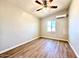 This bedroom features wood plank flooring, a ceiling fan, and a mini split AC unit at 2258 E Alpine Ave, Mesa, AZ 85204