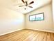 This bedroom features wood plank flooring, a ceiling fan, and a window at 2258 E Alpine Ave, Mesa, AZ 85204
