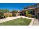 The tranquil backyard has a covered patio, artificial turf, travertine pavers, and mature desert landscaping at 2321 W Brookhart Way, Phoenix, AZ 85085