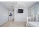 Bright bedroom features neutral walls, carpet, window, ceiling fan, and wall-mounted television at 2321 W Brookhart Way, Phoenix, AZ 85085