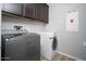 Bright laundry room with front loading Maytag washer/dryer and overhead dark wood cabinets at 2321 W Brookhart Way, Phoenix, AZ 85085